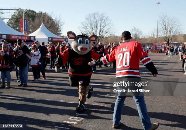 Stormy of the Carolina Hurricanes greets a fan at the Truly Hard Seltzer NHL Pregame at Carter-Finley Stadium on February 18, 2023 in Raleigh, North...