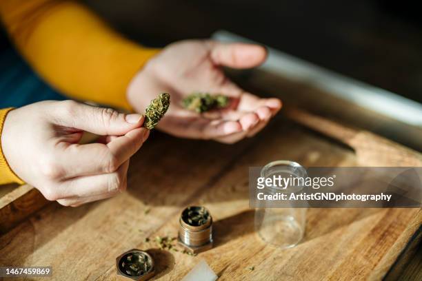 junger mann rollt einen marihuana-joint. - joint body part stock-fotos und bilder