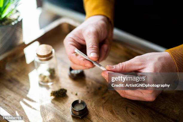 nahaufnahme der hände eines mannes, der einen joint mit marihuana zubereitet. - human joint stock-fotos und bilder