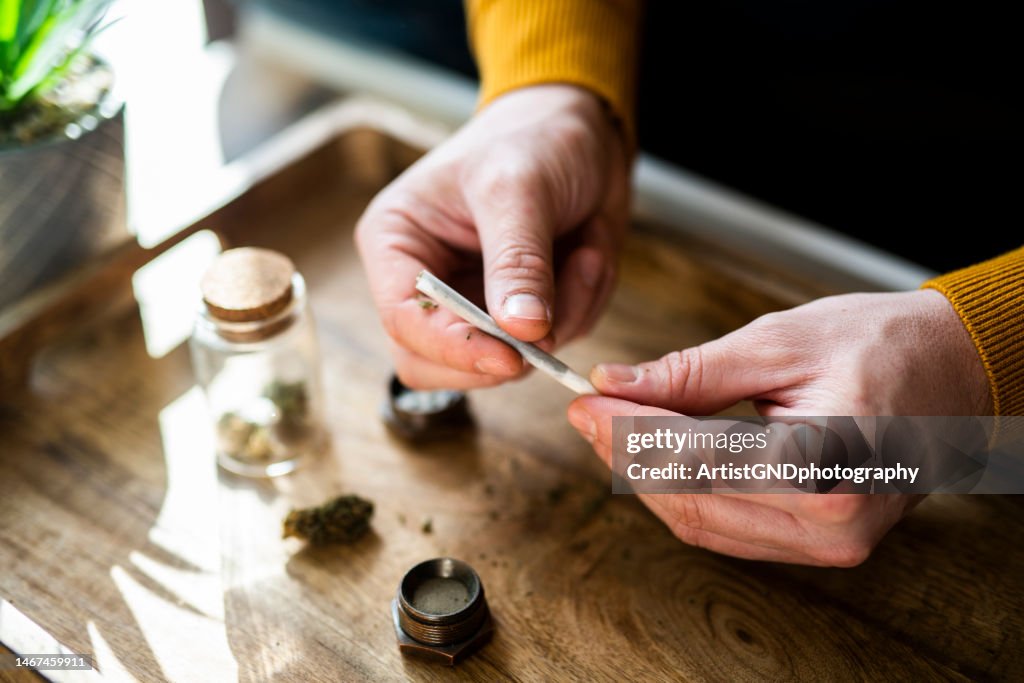 Close-up of a man's hands preparing a joint of marijuana.
