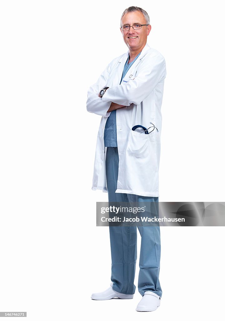 Male doctor standing with arms crossed against white background