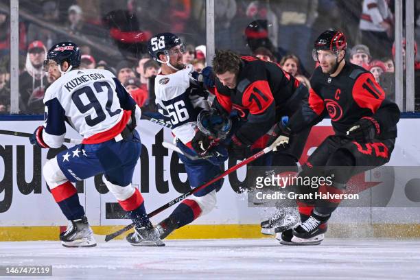 Erik Gustafsson of the Washington Capitals and Jesper Fast of the Carolina Hurricanes compete for the puck during the second period in the 2023 Navy...