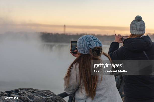 women taking photos of the falls in niagara - horseshoe falls niagara falls stock pictures, royalty-free photos & images