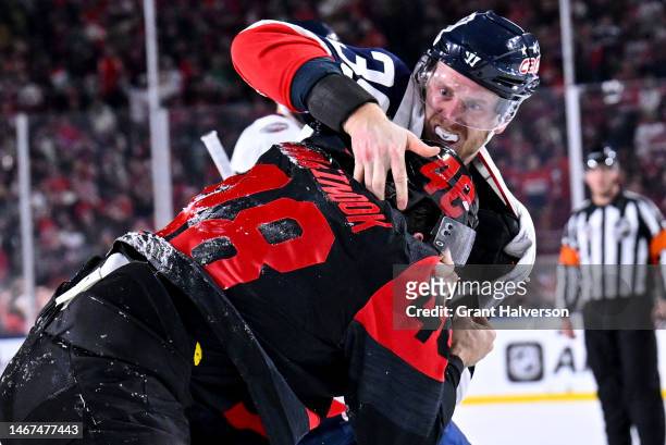 Jordan Martinook of the Carolina Hurricanes and Anthony Mantha of the Washington Capitals fight during the second period in the 2023 Navy Federal...