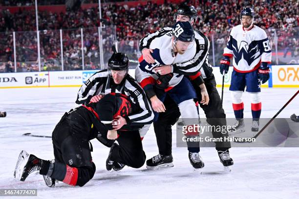 Jordan Martinook of the Carolina Hurricanes and Anthony Mantha of the Washington Capitals fight during the second period in the 2023 Navy Federal...