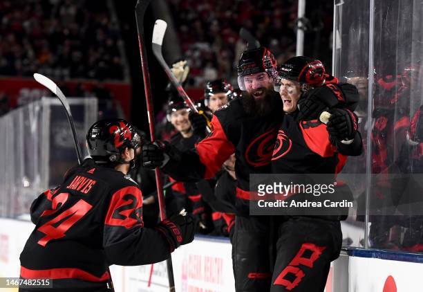 Seth Jarvis, Brent Burns and Martin Necas of the Carolina Hurricanes celebrate Necas' power play goal in the second period during the 2023 Navy...