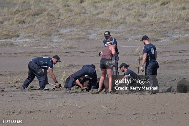 People rescue a cow stuck in river silt on February 19, 2023 in Napier, New Zealand. Cyclone Gabrielle has caused widespread destruction across New...