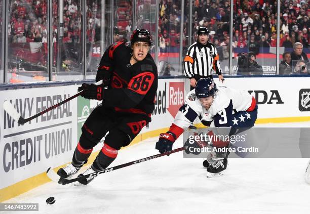 Teuvo Teravainen of the Carolina Hurricanes plays the puck away from Nick Jensen of the Washington Capitals in the second period during the 2023 Navy...