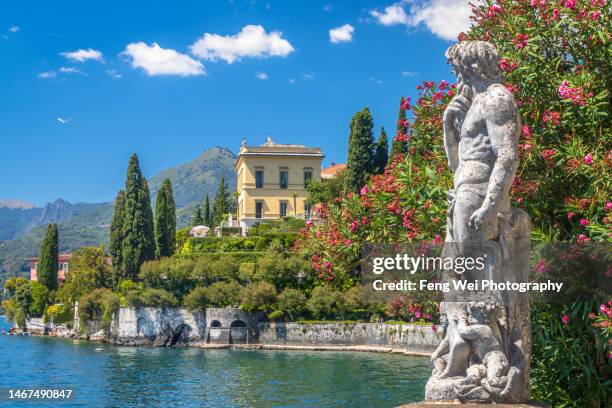 varenna, lombardy, italy - july 2022: statue in villa monastero overlooking lake como - lake como stock-fotos und bilder