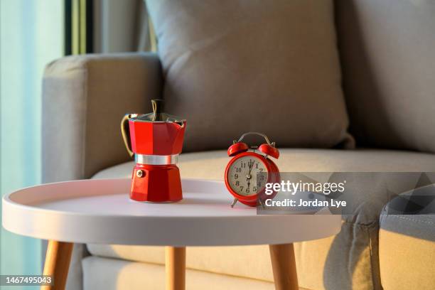 red coffee pot and alarm clock on the coffee table - orange alarm clock stock pictures, royalty-free photos & images
