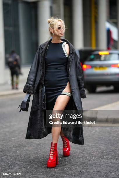 Betty Bachz wears black vintage sunglasses, silver earrings, a back with embroidered large crystals borders halter-neck / cut-out waist / asymmetric...