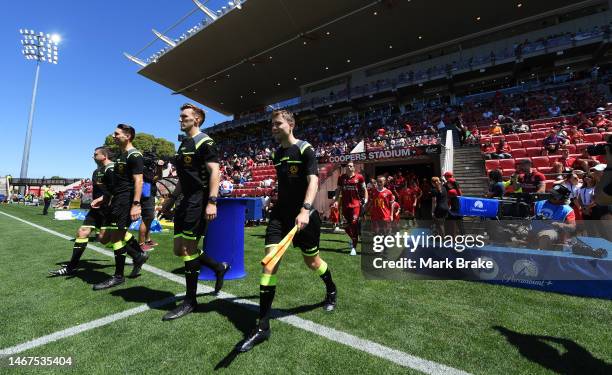 Referees lead out the teams during the round 17 A-League Men's match between Adelaide United and Western Sydney Wanderers at Coopers Stadium, on...