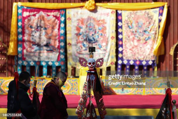 Tibetan Buddhist monk guard a ghost shape in the Beating Ghosts ritual at the Yonghegong Lama Temple on February 19, 2023 in Beijing, China. The...