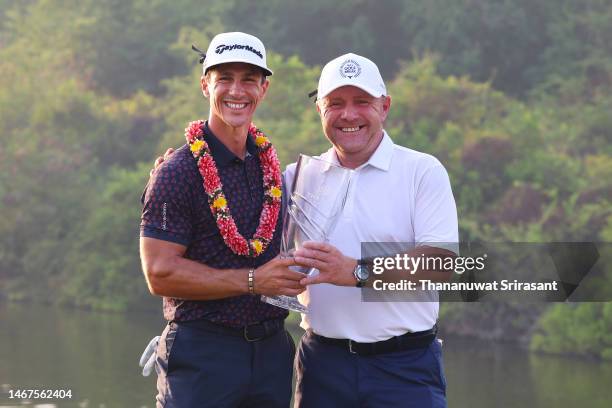 Thorbjorn Olesen of Denmark poses with the Thailand Classic Trophy after winning the Thailand Classic alongside their caddie, Dominic Bott at Amata...