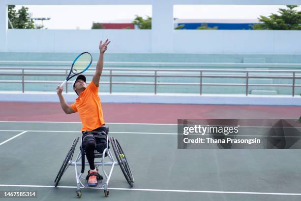 men in wheelchair playing tennis and conquer adversity - athlète handicapé photos et images de collection