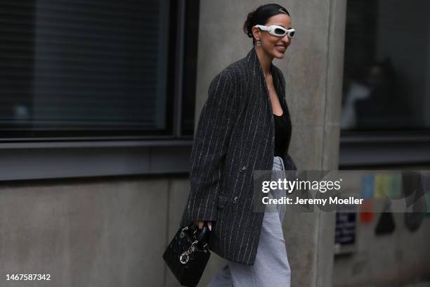 Bettina Looney seen wearing a lady Dior bag, grey jogging pants, white shades, black heels, a transparent black top and an oversized blazer before...