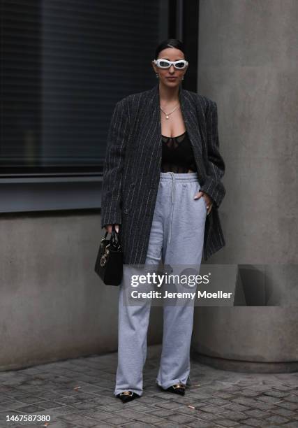 Bettina Looney seen wearing a lady Dior bag, grey jogging pants, white shades, black heels, a transparent black top and an oversized blazer before...