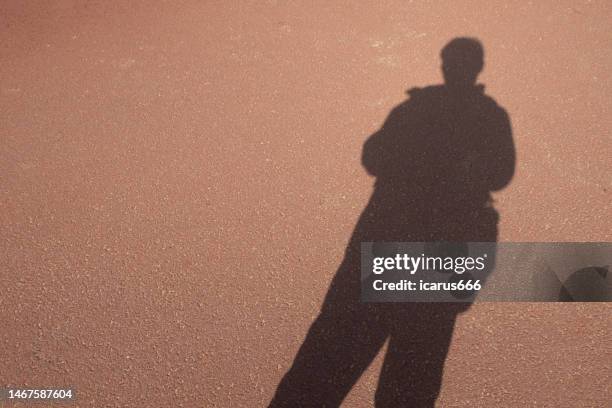 shadow of a person on the road - agoirento imagens e fotografias de stock