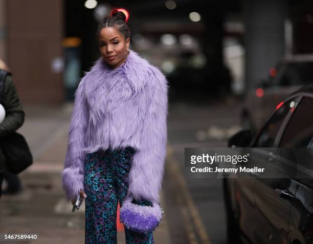 Ellie Delphine seen wearing a purple fluffy jacket, flower patterned pants, a matching purple mini bag and yellow heels before the DAVID KOMA show...