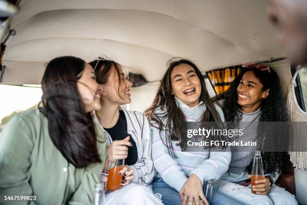 girlfriends having a conversation while drinking soda inside a van - drinking soda in car stock pictures, royalty-free photos & images