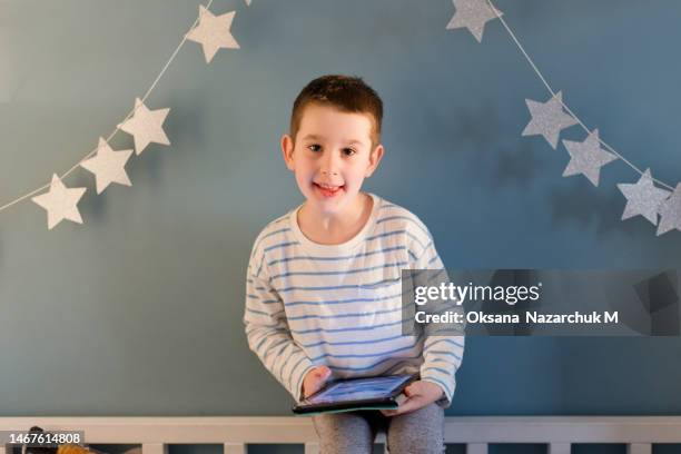 boy playing on a tablet indoors - kid touch screen wall stock pictures, royalty-free photos & images