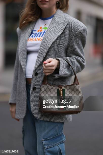 Sonia Lyson seen wearing H&M white printed shirt und blue denim cargo jeans pants, Gucci grey wool blazer, Gucci Jackie 1961 brown logo pattern bag,...