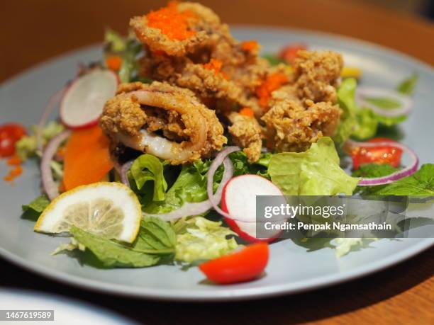 deep-fried calamari with spicy salad vegetable - cook battered fish stock pictures, royalty-free photos & images