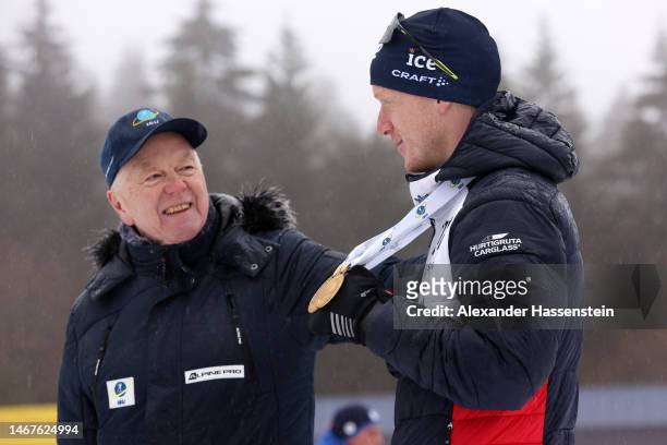 Johannes Thingnes Boe of Norway interacts with IBU President Olle Dahlin during the medal ceremony for the Men 15 km Mass Start at the IBU World...