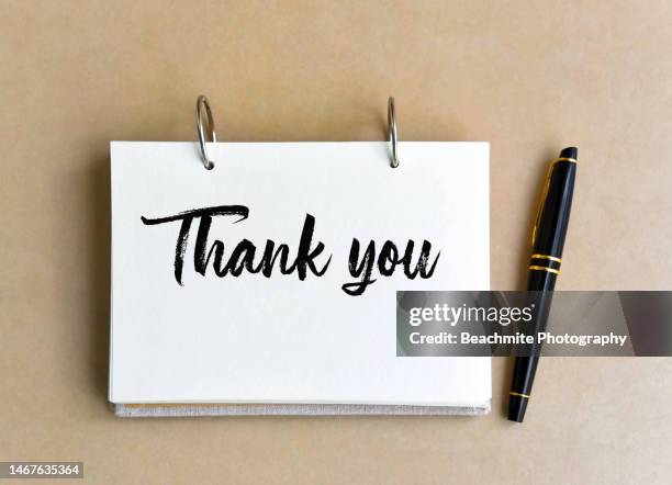 note pad with the text " thank you" and a pen on a table - thank-you stock pictures, royalty-free photos & images