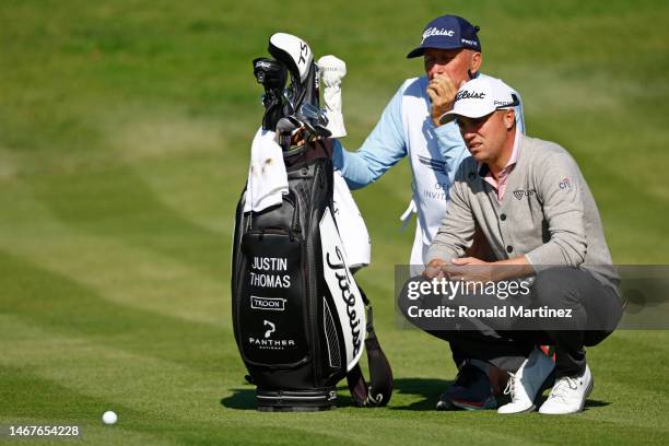 Justin Thomas of the United States and his caddie, Jim "Bones" Mackay, line up a putt on the fourth green during the final round of the Genesis...