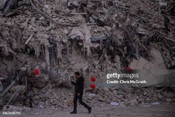 Man walks in front of rubble from destroyed buildings on February 19, 2023 in Hatay, Turkey. A 7.8-magnitude earthquake hit near Gaziantep, Turkey,...