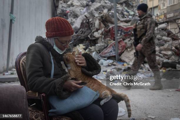 Syrian woman cuddles a cat amid the rubble of destroyed buildings on February 19, 2023 in Hatay, Turkey. A 7.8-magnitude earthquake hit near...