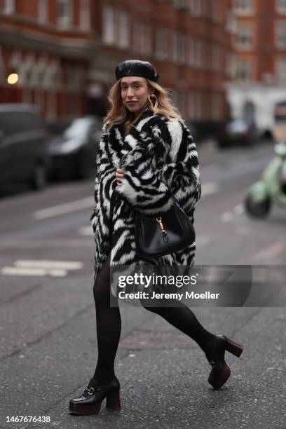 Sonia Lyson seen wearing Gucci black leather beret hat, gold triangle statement earrings, Gucci Jackie 1961 black leather shoulder bag, black tights,...