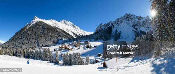 winter landscape with snowcapped mountains - mountain village stockfoto's en -beelden