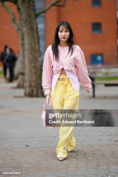 Guest wears a pale pink cut-out chest / asymmetric cropped sweater, a pale pink and white striped print pattern shirt, high waist pale yellow laces...