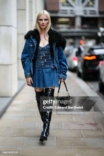 Guest wears a navy blue denim with black sheep large collar zipper bomber coat, a navy blue denim belted / pleated short dress, a black shiny leather...