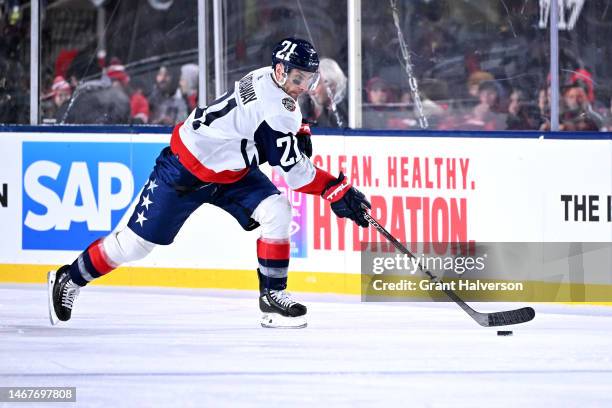 Garnet Hathaway of the Washington Capitals moves the puck against the Carolina Hurricanes during the 2023 Navy Federal Credit Union NHL Stadium...