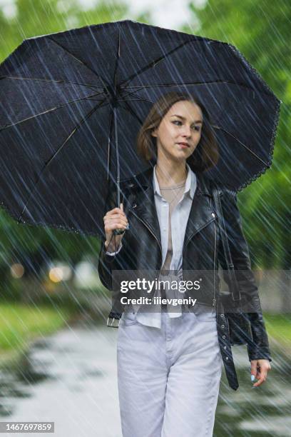 woman with black umbrella. rain. raindrops. wet asphalt - female fashion with umbrella stock pictures, royalty-free photos & images