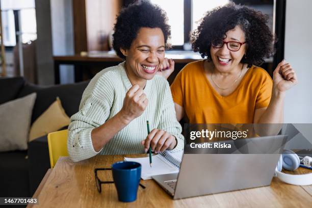 two excited mature woman looking at a laptop - exciting stock pictures, royalty-free photos & images