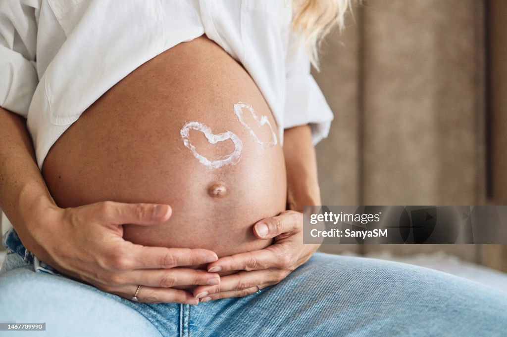 Pregnant woman embracing her belly
