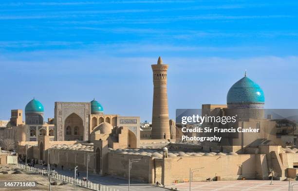 majestic "poi kalan" complex in central bukhara with "mir-i-arab" madrassah, "kalan mosque" ("masjid-i kalan") blue dome and massive "kalan minaret" ("kalyan") in the center in bukhara, uzbekistan - silk road stock pictures, royalty-free photos & images