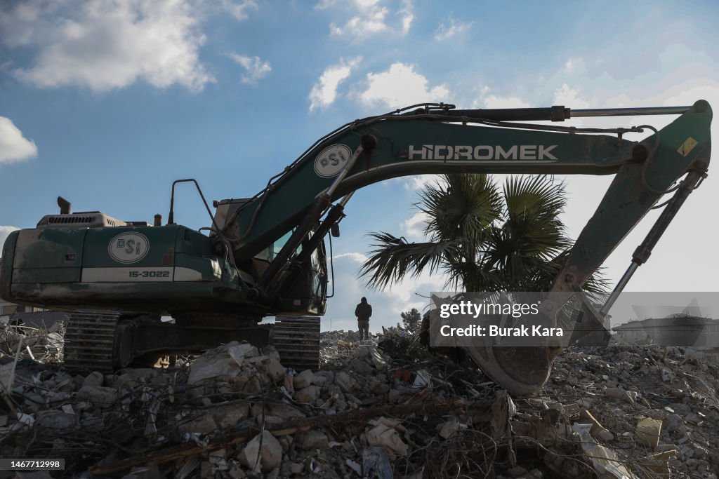 Collapted Machine A man stands behind a work machine on the debris of collapsed... News ...