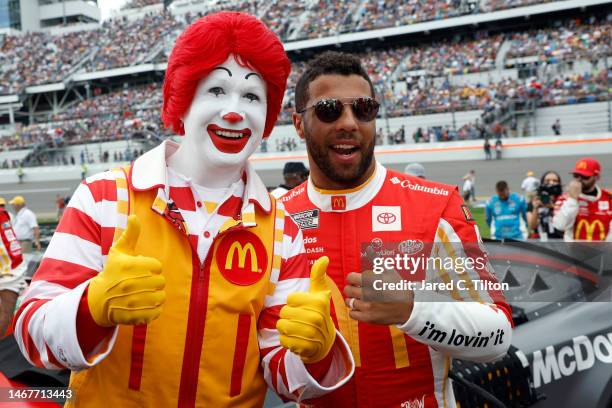 Bubba Wallace, driver of the McDonald's Toyota, poses wit Ronald McDonald on the grid. Prior to the NASCAR Cup Series 65th Annual Daytona 500 at...