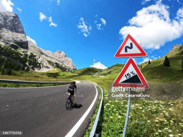 young woman cycling around dolomites in italy - steep road stock pictures, royalty-free photos & images
