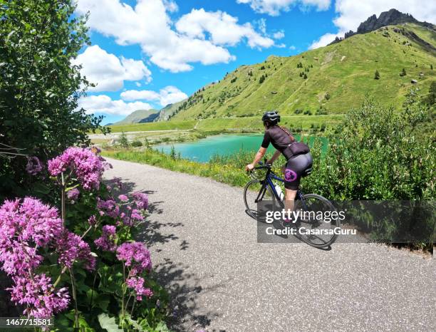 young woman cycling around dolomites in italy - trentino stock pictures, royalty-free photos & images