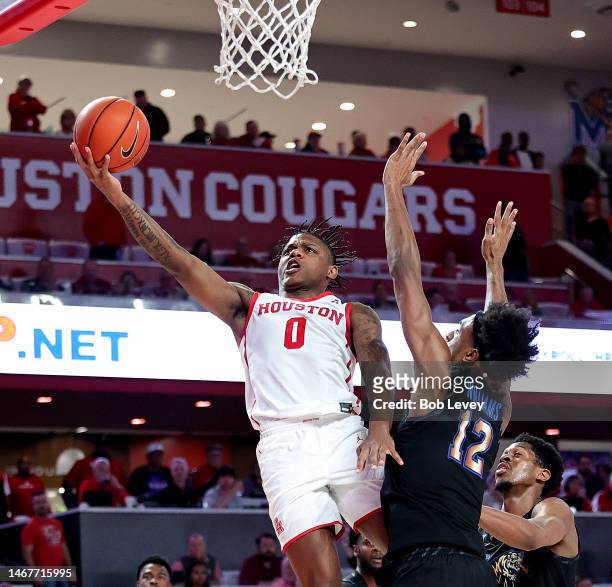 Marcus Sasser of the Houston Cougars drives past DeAndre Williams of the Memphis Tigers for a layup during the second half at Fertitta Center on...