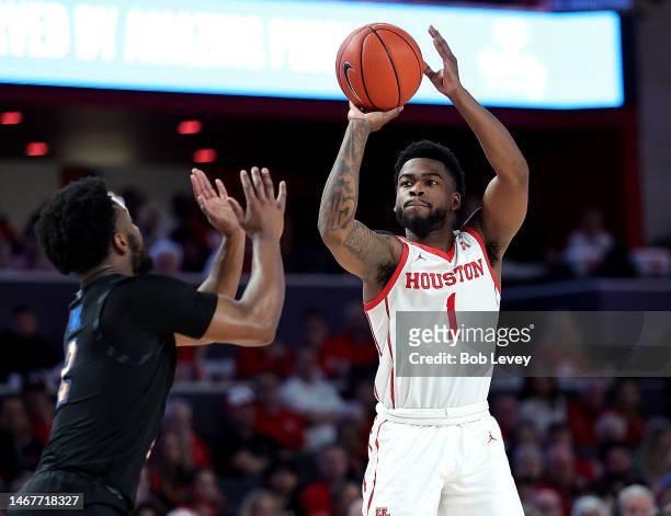 Jamal Shead of the Houston Cougars shoots over Alex Lomax of the Memphis Tigers during the second half at Fertitta Center on February 19, 2023 in...