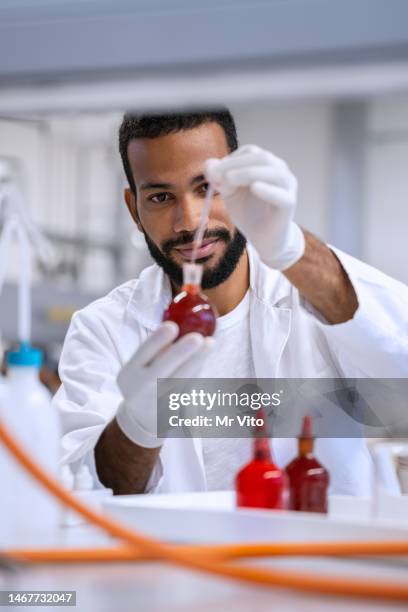 chemistry professor and students in the laboratory - luva vermelha imagens e fotografias de stock