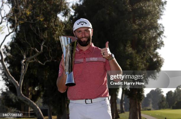 Jon Rahm of Spain celebrates with the trophy after putting in to win The Genesis Invitational at Riviera Country Club on the 18th green on February...