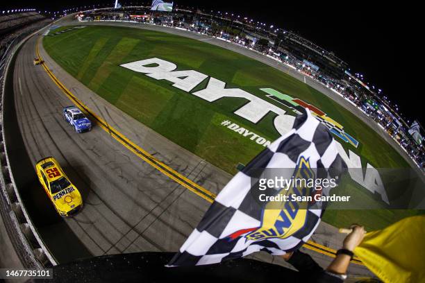 Ricky Stenhouse Jr., driver of the Kroger/Cottonelle Chevrolet, and Joey Logano, driver of the Shell Pennzoil Ford, race to the checkered flag under...